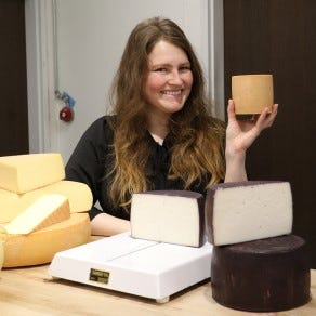 Image of Cheese Monger hand cutting cheese to order. 